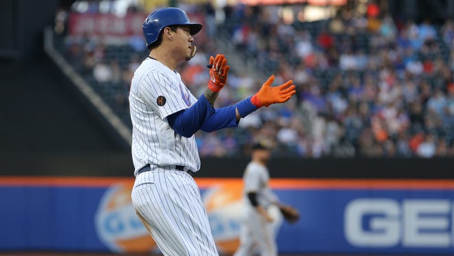New York Mets first baseman Wilmer Flores (4) reacts after hitting a two run single against the Pittsburgh Pirates and advancing to third on an error during the first inning at Citi Field.