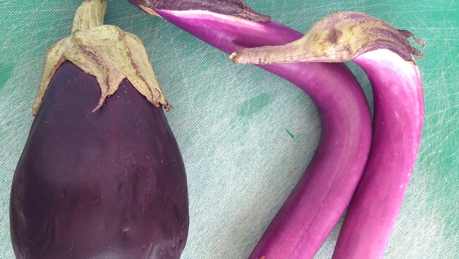 The fruit of the Japanese eggplant on the right has thinner skin than the more common egg-shaped variety on the left.
