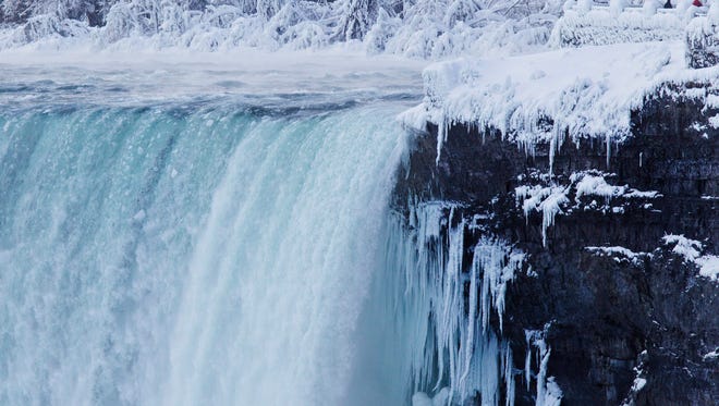 Visitors look over masses of ice formed around the Canadian Horseshoe Falls in Niagara Falls, Ontario, Thursday, Feb. 19, 2015. (AP Photo/The Canadian Press,Aaron Lynett) 