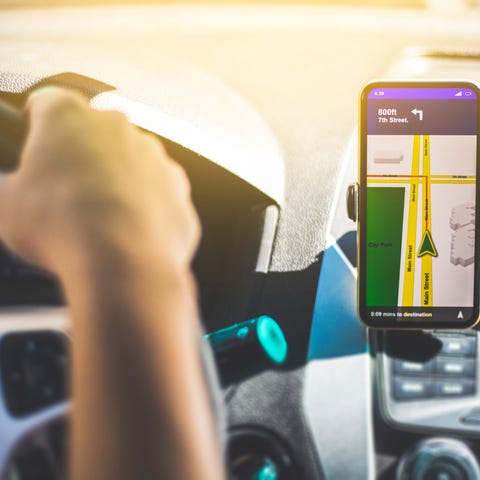 A driver behind the wheel looking at a GPS map on 