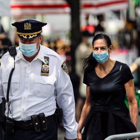 A police officer wears a protective mask as he wal