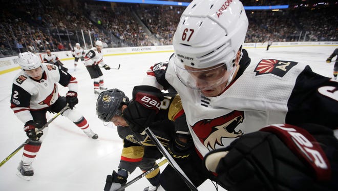 Coyotes left wing Lawson Crouse (67) and Golden Knights center Jonathan Marchessault (81) battle for the puck on Tuesday.