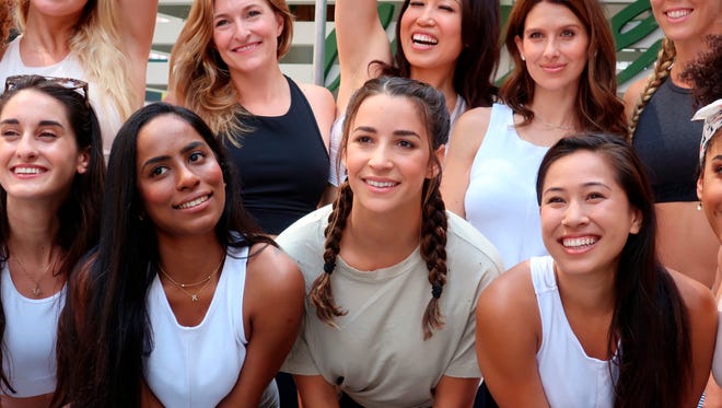 In this June 21, 2018, file photo, Olympian Aly Raisman, center, poses with other yoga enthusiasts on International Yoga Day in Times Square in New York. Raisman told The Improper Bostonian magazine, for a story published June 22, that she's barely been able to work out since going public with allegations of sexual abuse at the hands of former USA Gymnastics team doctor Larry Nassar.