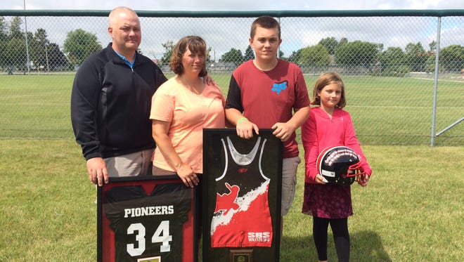 The West family received several gifts including framed jerseys, photos and a football helmet from coaches and the Sevastopol School District as part of the celebration. Pictures are Shawn (left), Aimee, Nick and Mackenzie West.