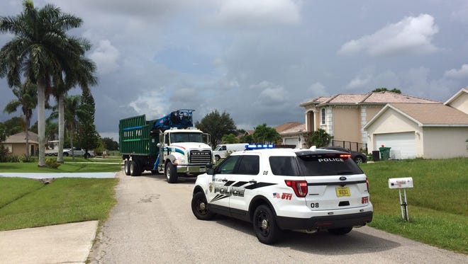 A waste truck knocks a utility pole onto the back of a home Tuesday in Port St. Lucie