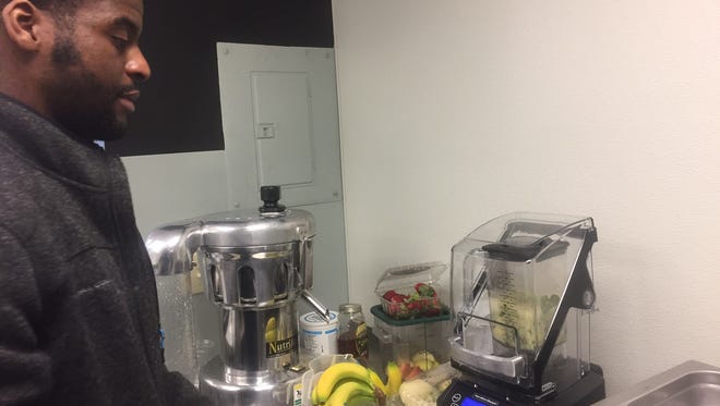 Owner Seth Amoah prepares to make a fresh-pressed juice at The Juice Bar in Merchantville.