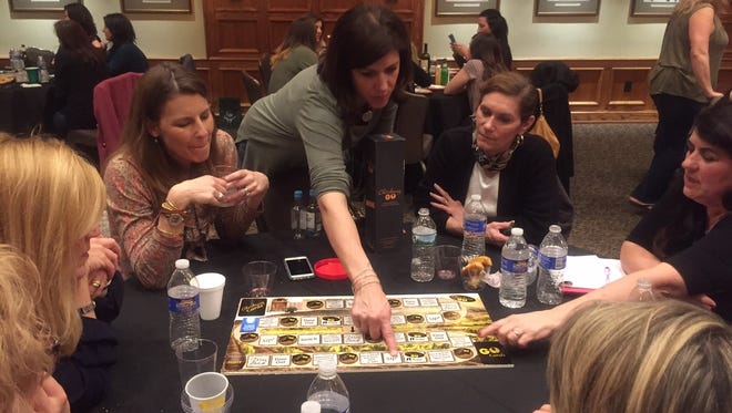 Dena Blizzard explains a prototype of ChardonnayGo! to a group of guests at the Moorestown Community last spring. The game, a spoof on PokemonGo, will be in stores soon.