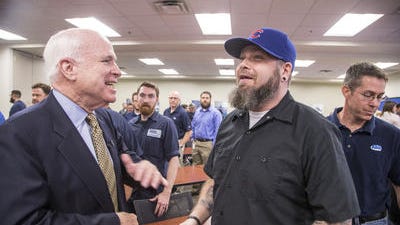 Sen. John McCain jokes with Randall Cook after an event in Mesa. Cook's cap prompted McCain, R-Ariz., to quip that anyone who shows up in Chicago Cubs hat again will be ejected. But years ago, McCain considered the Cubs his favorite team.