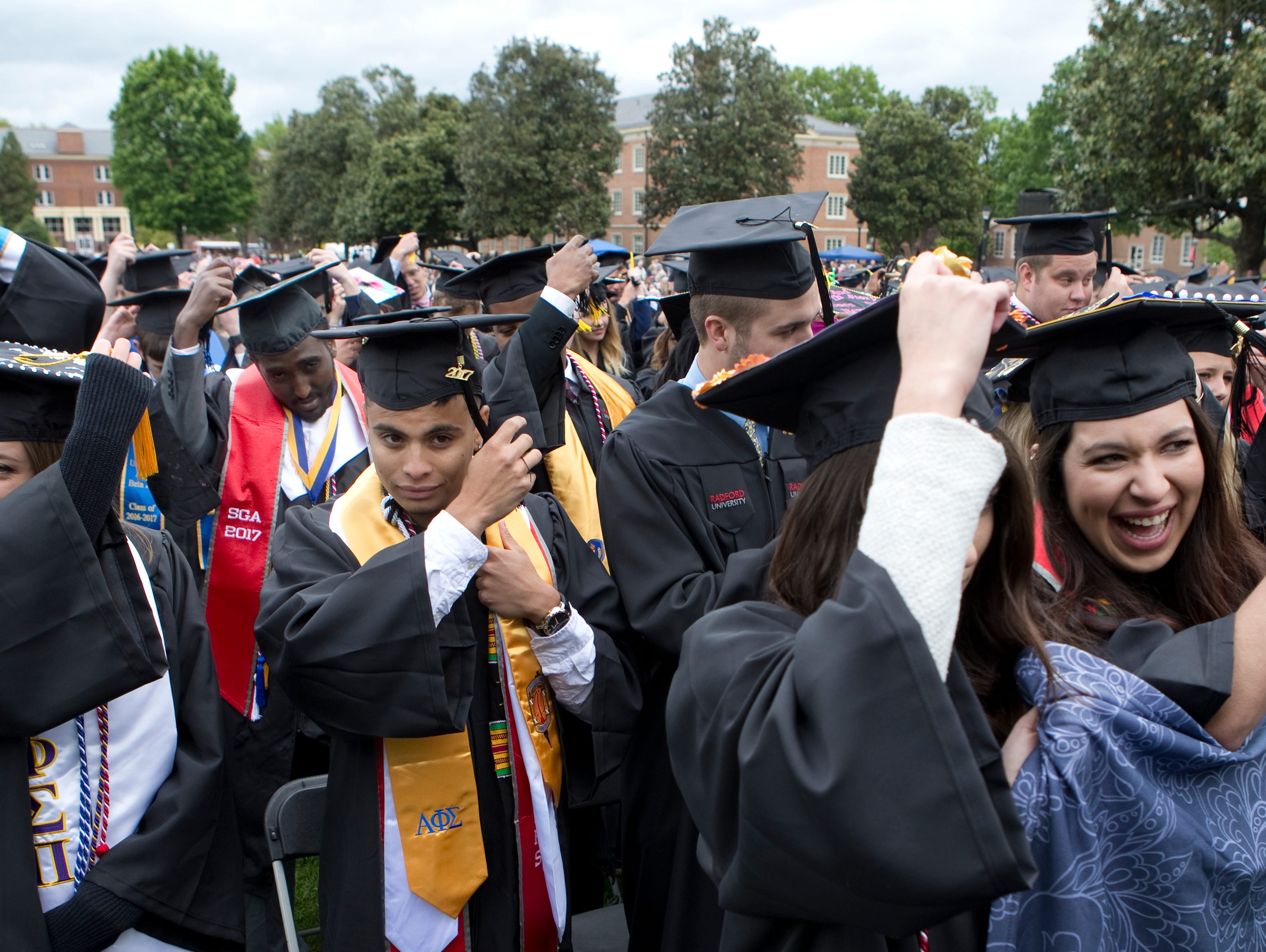 Graduates turn their tassels during the conferring of degrees portion of the commencement ceremony at Radford University May 6, 2017.