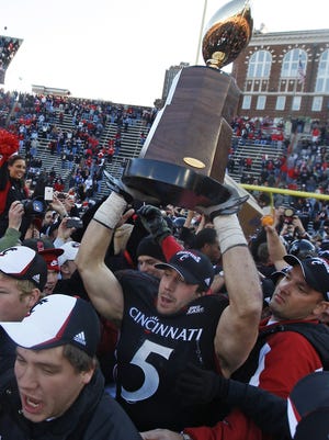 The Unversity of Cincinnati's Connor Barwin celebrates with the Big East Championship trophy after beating Syracuse 30-10 at Nippert Stadium in 2008.