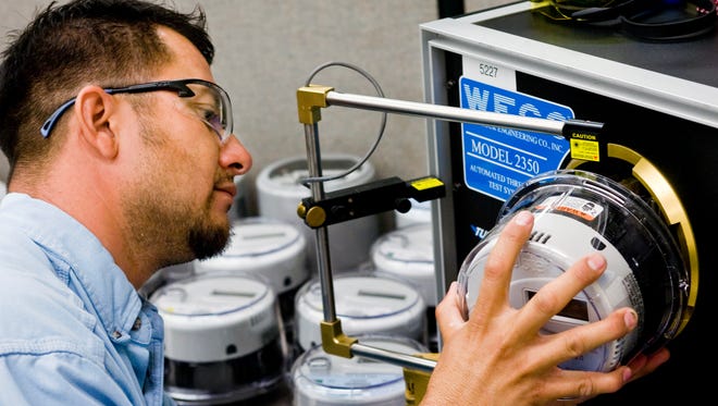 APS single-phase meter man Diego Celaya tests a smart meter before it's installed on a residence in 2010.