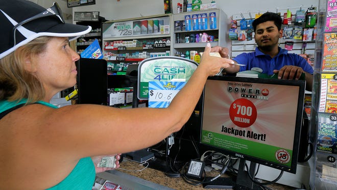 Laura Smith of Ocean Twp. buys a Powerball lottery ticket from Ben Singh, cashier, at Green Grove Mobil in Neptune, NJ Wednesday August 23, 2017.  The jackpot is up to 700 million dollars.