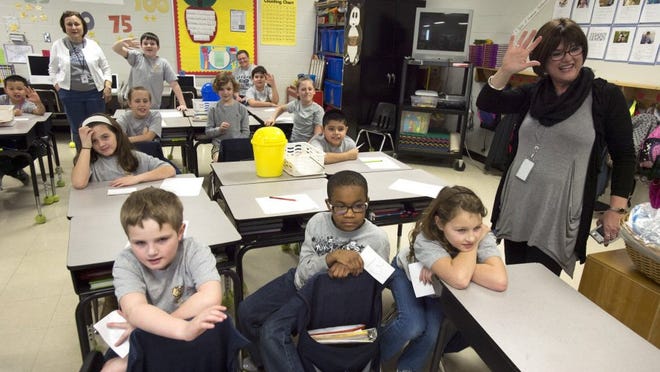 Lakeland Elementary School third-grade teacher Renee Pirkey (right) waves along with her students, including (front, from left) Jacob Scarborough, 8, Dylan Gordan, 9, and Lorelei Klobe, 9, during a video conference with their pen pal, a dog named Naomi, on Feb. 19, 2016.
