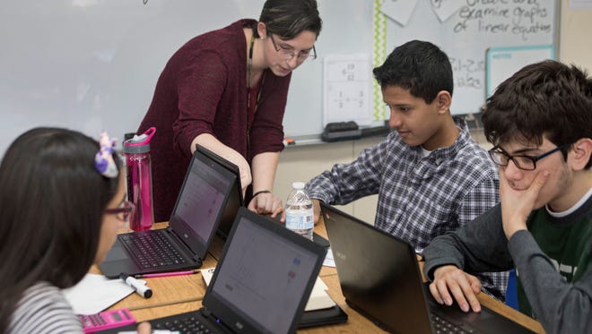 During an eighth-grade lession, math teacher Jamie Rifkowski helps Leonardo Torres, 14, use a learning program that blends technology with traditional instruction at the Slocum Skewes School in Ridgefield.