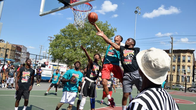 Passaic residents battling it out on the basketball court at the Doing It in the Park playground festival in Passaic.