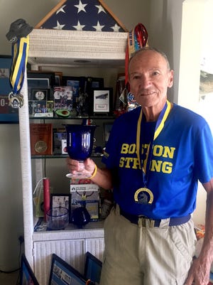Johnny Ouweleen stands in front of his trophy case at his home in Sebastian.
