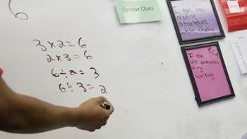A teacher explains a math problem at Detroit Merit Charter Academy in Detroit in 2013.