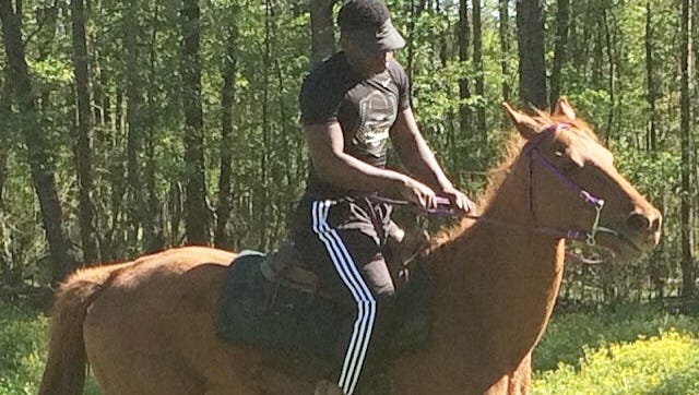 North DeSoto running back Delmonte Hall rides Brown Sugar, his Thoroughbred horse.