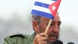 Cuban President Fidel Castro shows a national banner