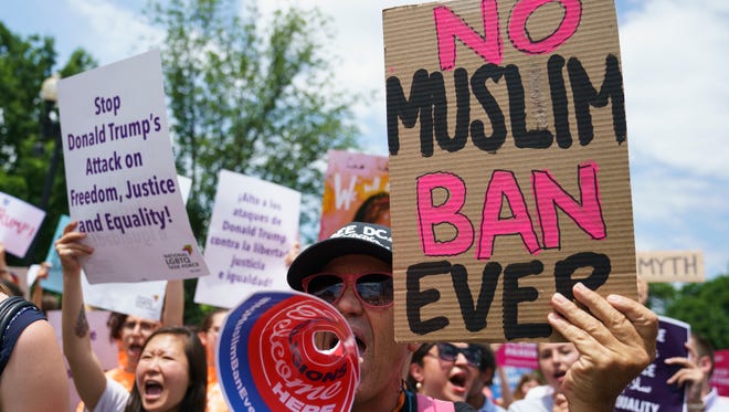 Protesters call out against the Supreme Court ruling upholding President Donald Trump's travel ban outside the Supreme Court on Capitol Hill in in Washington, Tuesday, June 26, 2018.