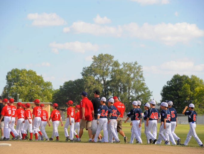 The teams march onto the ball field during opening