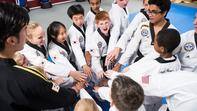 The So's Taekwondo competition team huddle up at the end of a training session on Wednesday, July 19, 2017. The team of 16 competitors recently traveled to Detroit to compete at the USA National Championships where they finished with a combined 12 medals. The national tournament is the largest martial arts competition in the world, with more than 3,500 participants.