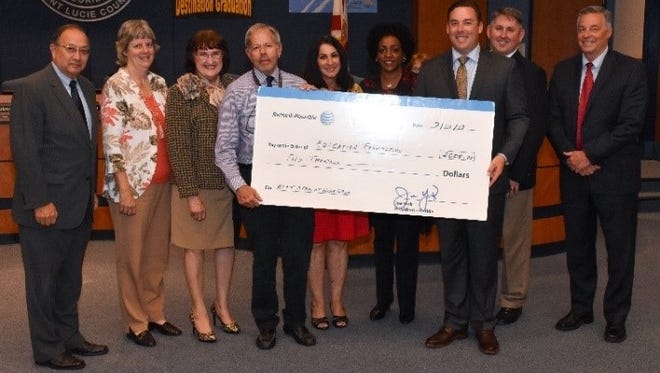 AT&T representatives present a check for $2,000 to St. Lucie County education officials.