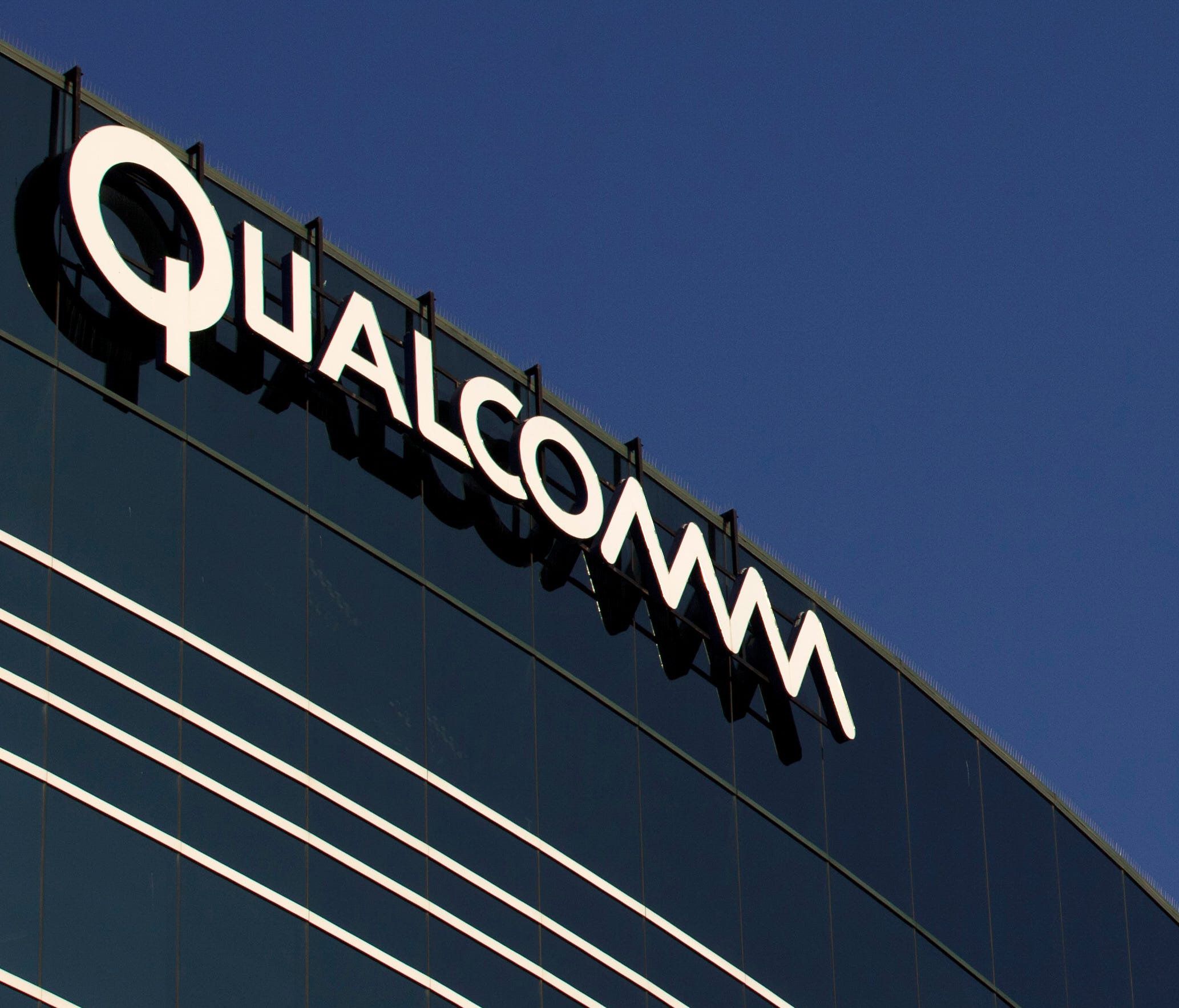 A sign sits atop the Qualcomm headquarters building in San Diego.  Qualcomm is raising its takeover bid for NXP Semiconductors by nearly 16 percent to about $43.22 billion, citing in part NXP's strong results since the companies first announced their