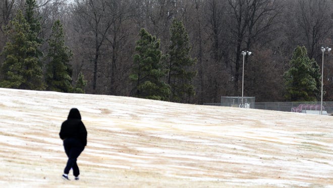 An unidentified person walks toward Muse Park on the icy ground Monday morning.
