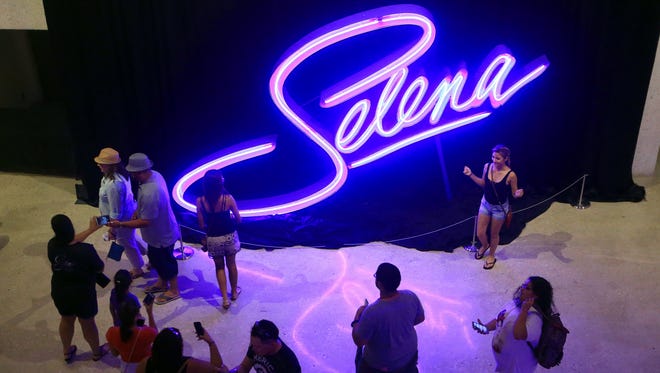 People take photos with a Selena sign during the second day of Fiesta de la Flor on Saturday, March 25, 2017, in Corpus Christi.