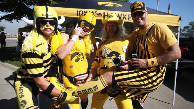 Hawkeye fans, from left, Morgan O'Conner, Jim Khana, Lance Neddler, and Eric Dolash pose for a photo while tailgating prior to the start of Iowa's game against Northern Iowa on Saturday in Iowa City. (Bryon Houlgrave/The Des Moines Register)