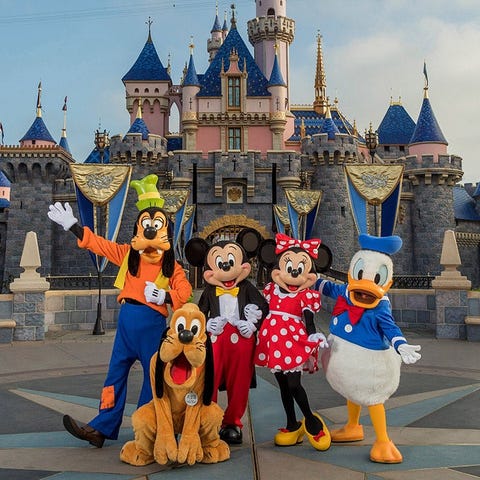 Disney characters in front of Disneyland's castle.
