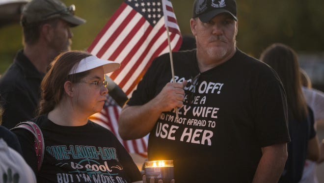 Outside a Phoenix police precinct headquarters on July 11, 2016, Sabrina Bruno holds a candle for her and her husband, Thomas, during a candlelighting ceremony in honor of the officers shot in Dallas.