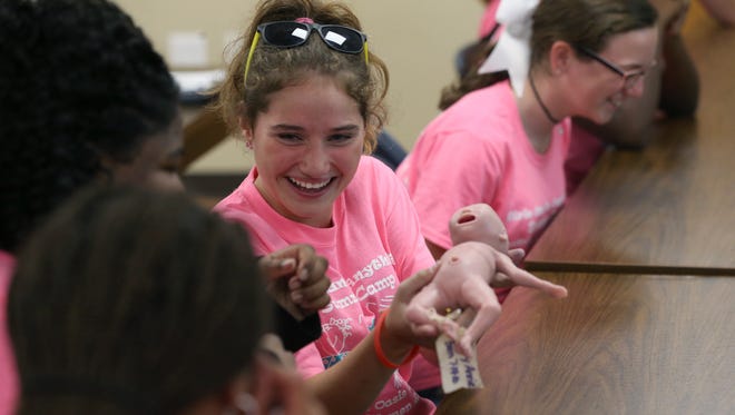 Kylie Robinson, 12, laughs with fellow young women as they hold ‘Little Annie”, a model of a premature baby, during a nursing recruitment class with Tallahassee Memorial Hospital for campers from the Oasis Center for Girls and Women on the hospital’s campus Thursday, June 8, 2017. 