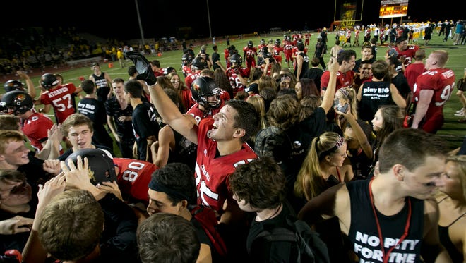Chaparral offensive lineman Ben Numankadic celebrates with teammates and students that rushed the field after the team's 52-27 win over Saguaro in the high school football game at Chaparral High School.