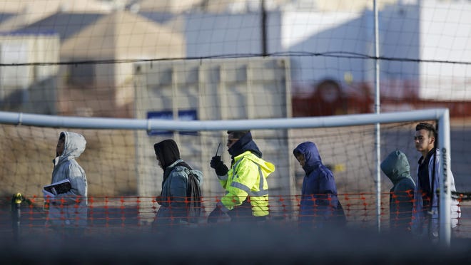 File-In this Dec. 13, 2018, file photo, teen migrants walk in line inside the Tornillo detention camp in Tornillo, Texas. Government investigators say many more migrant children may have been separated from their parents than the Trump administration has acknowledged. (AP Photo/Andres Leighton, File)