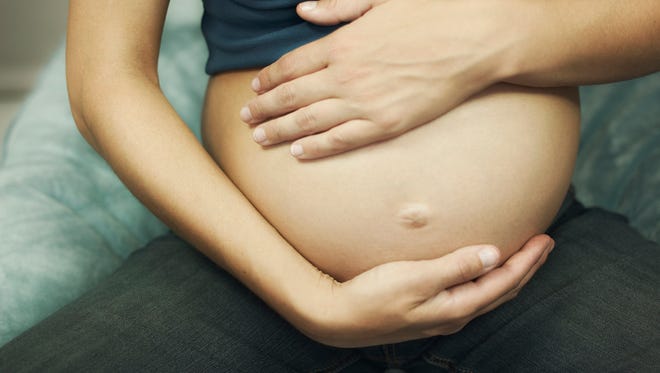 Cropped pregnant woman touching belly
