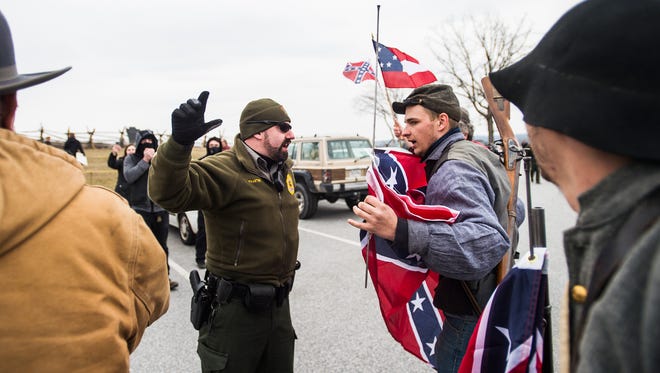 Park Rangers with Gettysburg National Military Park prevent Confederate flag supporters from getting near a group of counter-protesters during the Confederate flag day at the Eternal Peace Light Memorial in Gettysburg, Pa., Saturday, March 5, 2016. (Shane Dunlap/The Evening Sun via AP)
