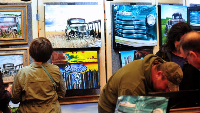 Patrons look at Saco, Montana, artist Todd Mandeville's booth at the Wild Bunch Show last year at the Hampton Inn,