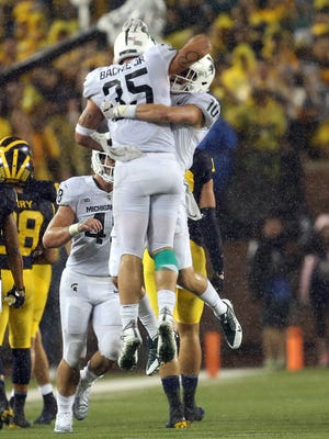 Michigan State Spartans linebacker Joe Bachie (35) and Michigan State Spartans safety Matt Morrissey (10) celebrate a interception during the second half of a game at Michigan Stadium.