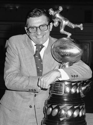FILE -  In this Dec. 6, 1973, file photo, Joe Paterno, head coach of the Penn State football team, clutches the Lambert Trophy in New York, after it was awarded to his team as emblematic of collegiate grid supremacy in the East. Penn State seeks to move on from the sexual abuse scandal that occurred during Paterno's tenure without abandoning the memory of a legendary figure.