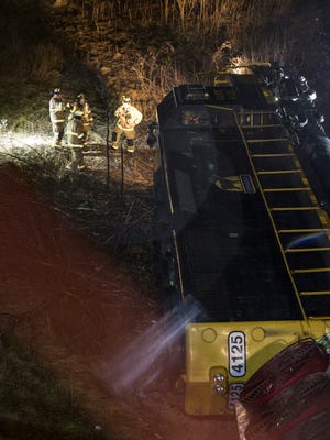 Firefighters and workers investigate a derailed train near U.S. 131 under 28th Street in Grand Rapids, Mich., on Tuesday, Feb. 20, 2018. An official says a washout from heavy rains may have caused two engines from a freight train to derail in western Michigan.