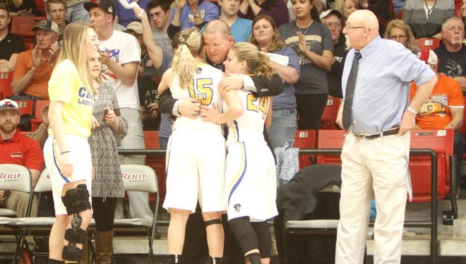 Crane girls basketball coach Jeremy Mullins (center) celebrates with seniors Justeen Mahan (15) and Kylee Moore (24) moments after Crane clinched a fourth consecutive berth in the Class 2 final four with a 64-48 win over Gainesville.