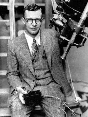 In this 1931 file photo, Clyde Tombaugh poses with the telescope through which he discovered the Pluto at the Lowell Observatory on Observatory Hill in Flagstaff, Ariz.