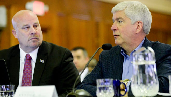 Budget Director Al Pscholka, left, listens as Gov. Rick Snyder presents his fiscal year 2018 and 2019 budget recommendation on Wednesday before the joint Senate and House Appropriations Committees at the Senate Hearing Room in Boji Tower in Lansing Mich.