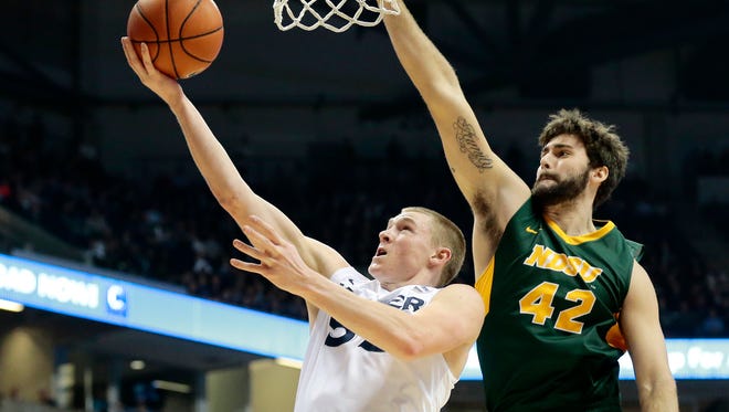 Xavier Musketeers guard J.P. Macura (55) throws up a layup past North Dakota State Bison forward Dylan Miller (42) during the first half of the NCAA men's basketball game between the Xavier Musketeers and the North Dakota State Bison at Xavier's Cintas Center in Cincinnati on Tuesday, Nov. 29, 2016. After one half Xavier led 43-22.