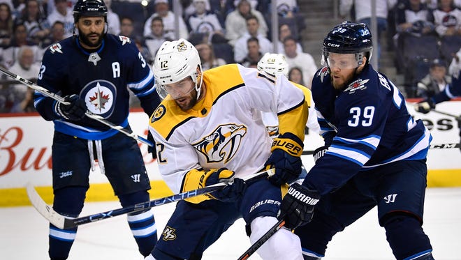 Nashville Predators center Mike Fisher (12) battles of the puck with Winnipeg Jets defenseman Toby Enstrom (39) during the first period of Game 3 in the second-round NHL Stanley Cup playoff series at Bell MTS Place in Winnipeg, Manitoba, Canada, Tuesday, May 1, 2018.
