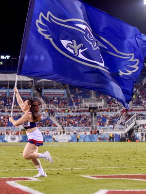 A Florida Atlantic Owls cheerleader and the flag.