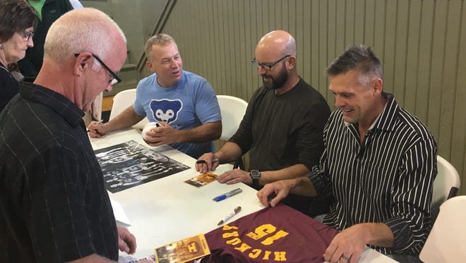 Wade Schenck (from left), David Neidorf and Maris Valainis, actors from the movie "Hoosiers," sign autographs Saturday at a viewing of the film at the Hoosier Gym in Knightstown.