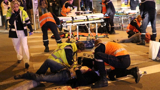 This photo provided Monday, Dec. 22, 2014 by local newspaper Le Bien Public shows rescue workers tending at victims after a driver deliberately slammed into passersby in several spots in Dijon, central France, Sunday Dec. 21, 2014. French police are raising security after an attack on officers in central France, and the country’s top security official is arriving in the city where a driver ran down 11 pedestrians.